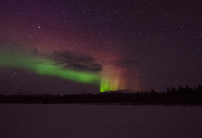 Aurora Borealis, or the Northern Lights appear bright in the night sky.