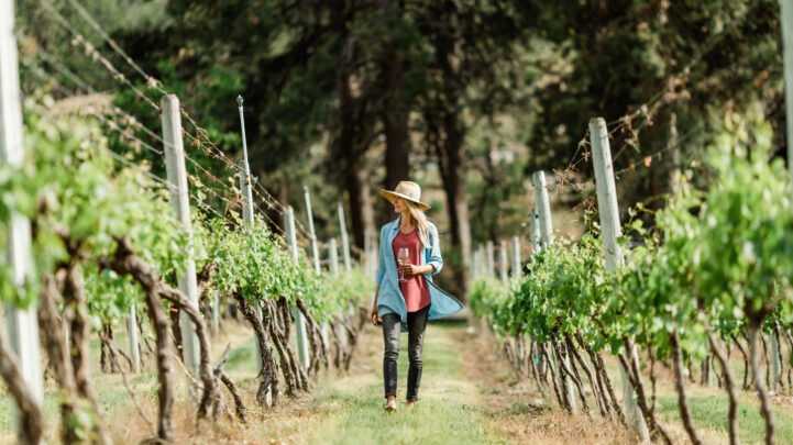Woman walking in vineyard with hat