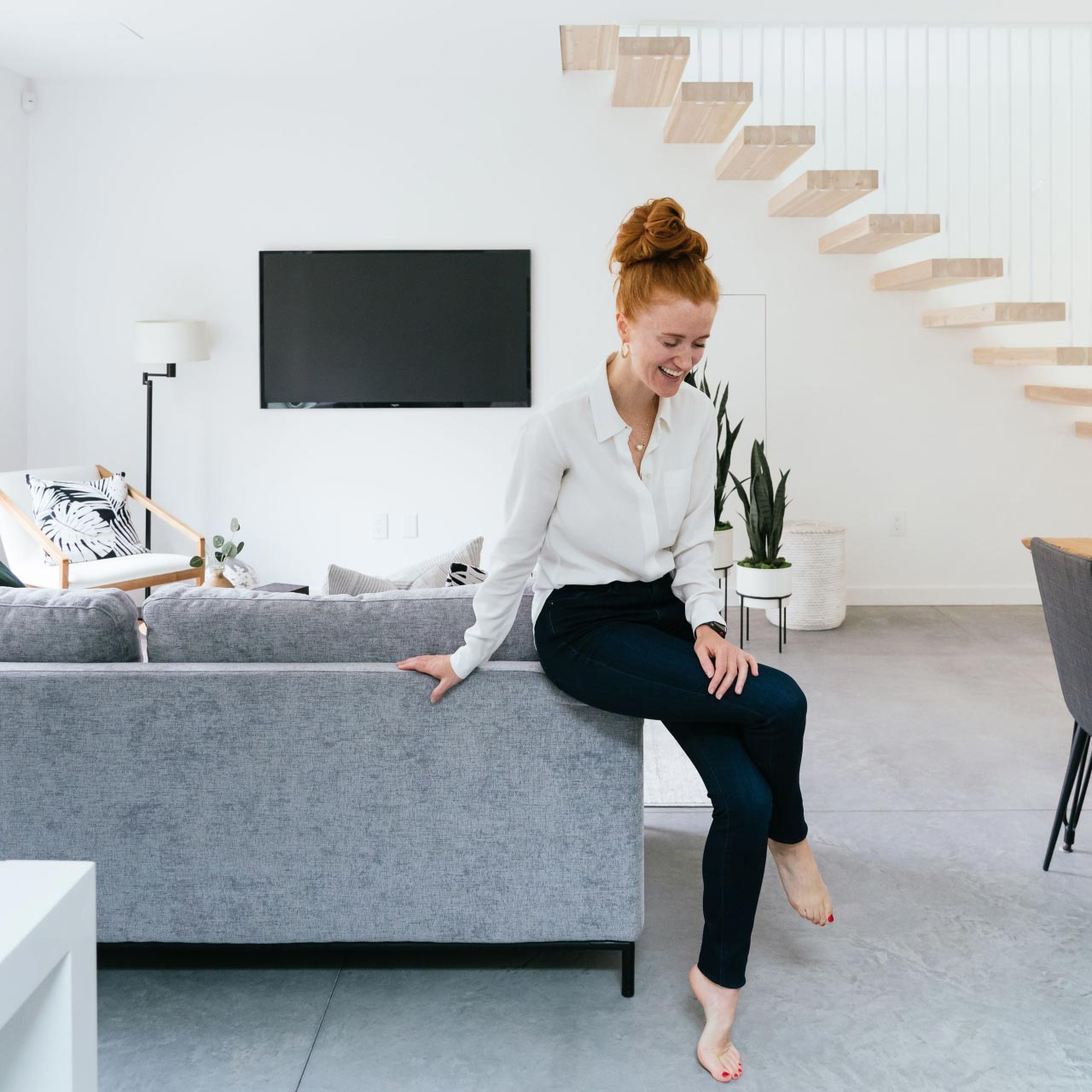 minimalist living room with staircase and woman